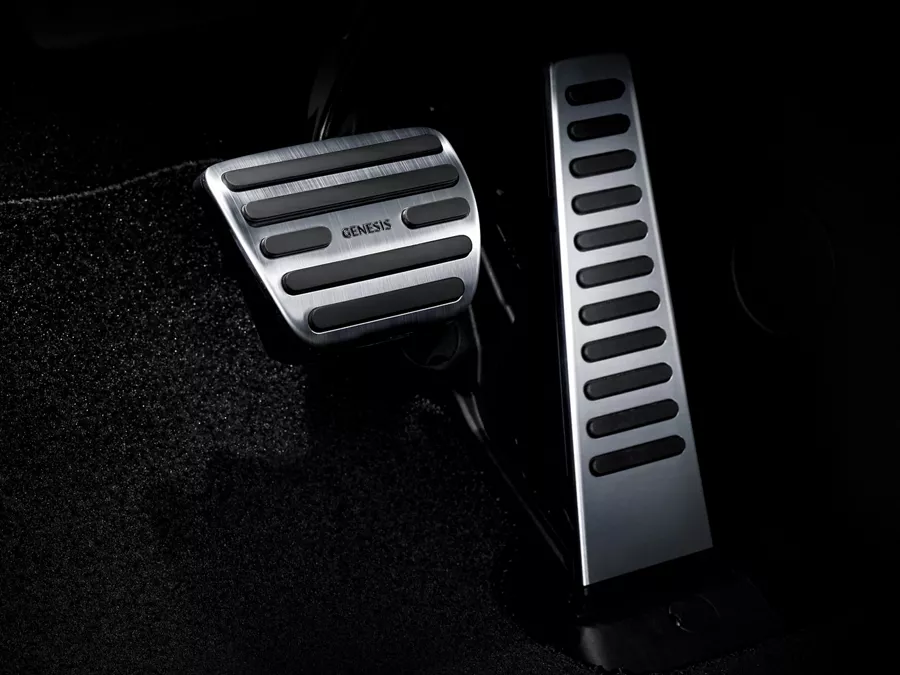 Interior close up of metal accelerator and brake pedals inside the 2027 Genesis GV60 Magma