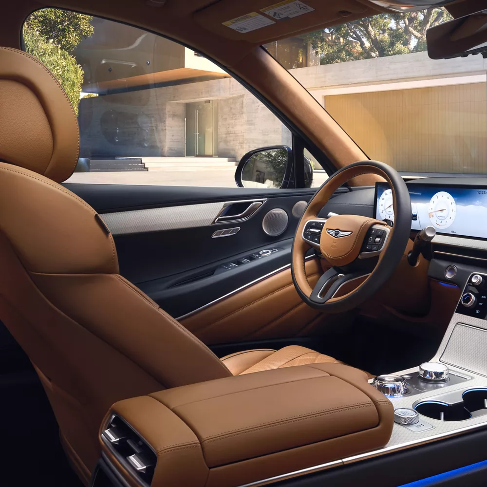 Interior view from passenger seat of Genesis GV80 cockpit in Dune tan color