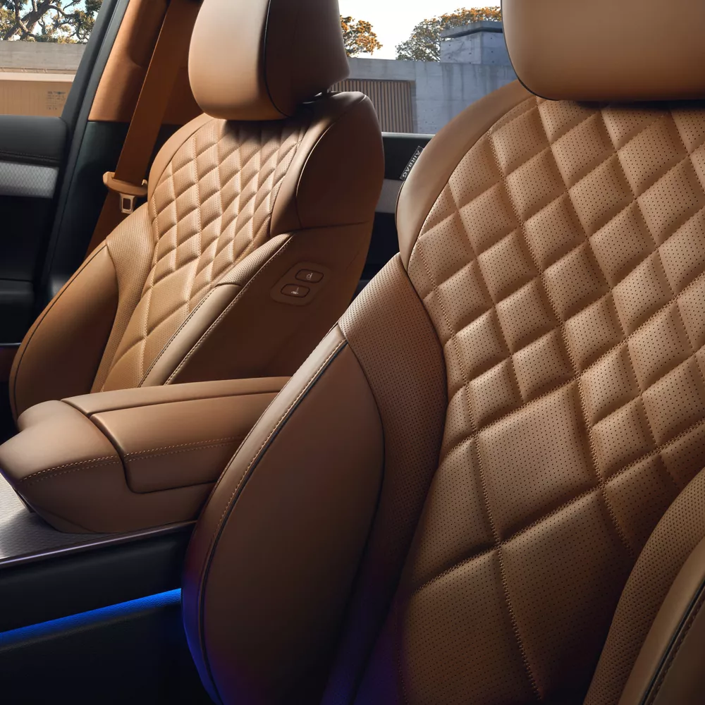 Interior close up from driver side pov of Genesis GV80 quilted Nappa leather seats in Dune tan color