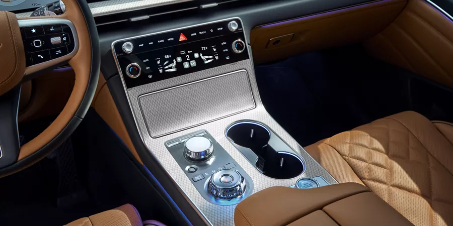 Close up interior shot of center controls and dials on Genesis GV80 with tan leather seats