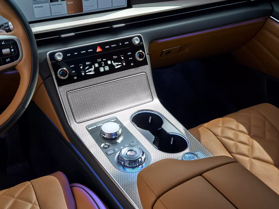 Close up interior shot of center controls and dials on Genesis GV80 with tan leather seats