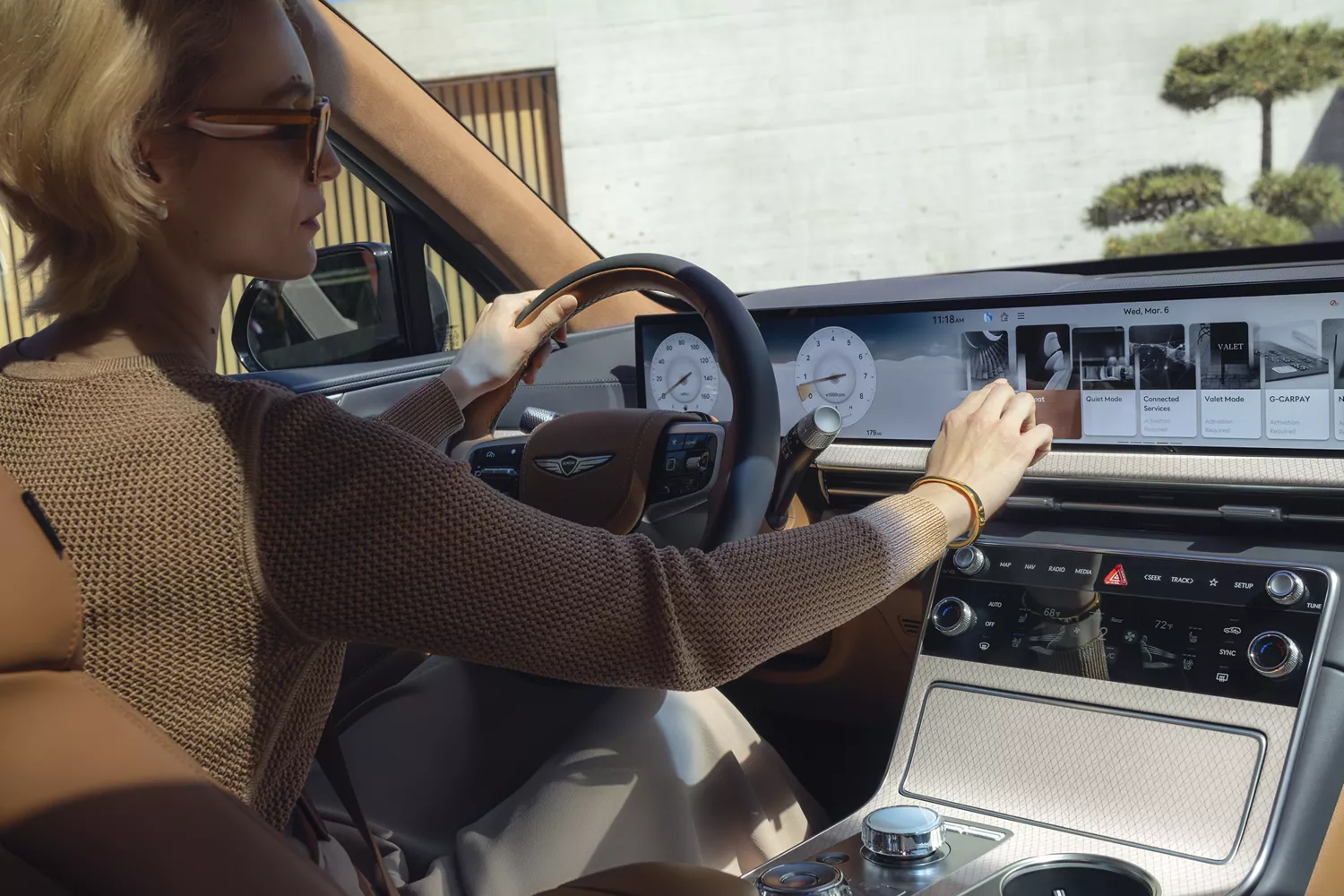 Interior pov of woman using SiriusXM on center infotainment screen inside 2026 Genesis GV80
