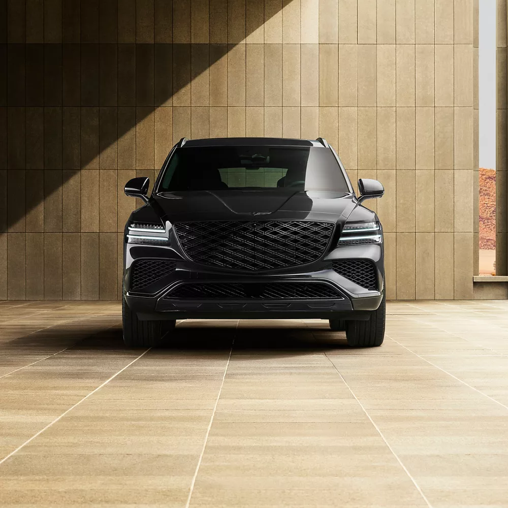 Front view of Genesis GV80 in Prestige Black parked in front of modern tan minimalist building