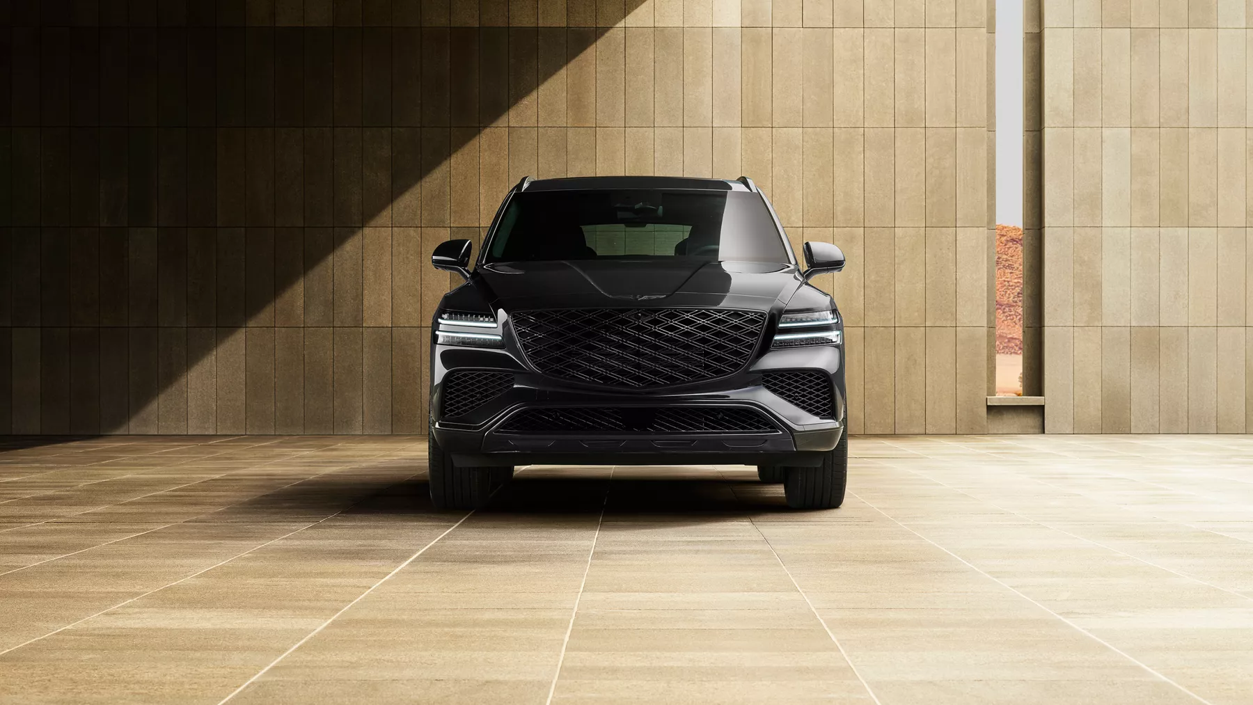 Front view of Genesis GV80 in Prestige Black parked in front of modern tan minimalist building