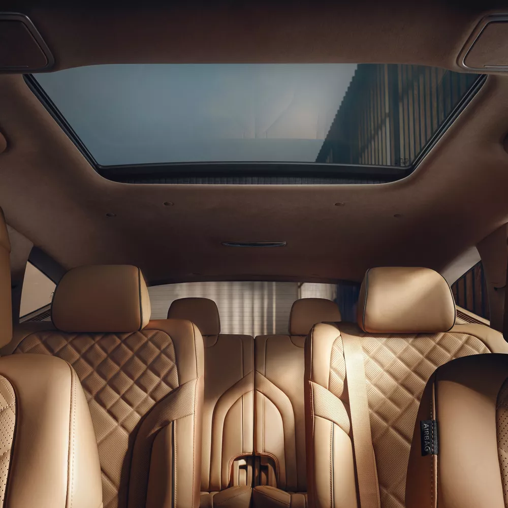 Interior dashboard pov of front and rear Dune tan quilted Nappa leather seating inside Genesis GV80