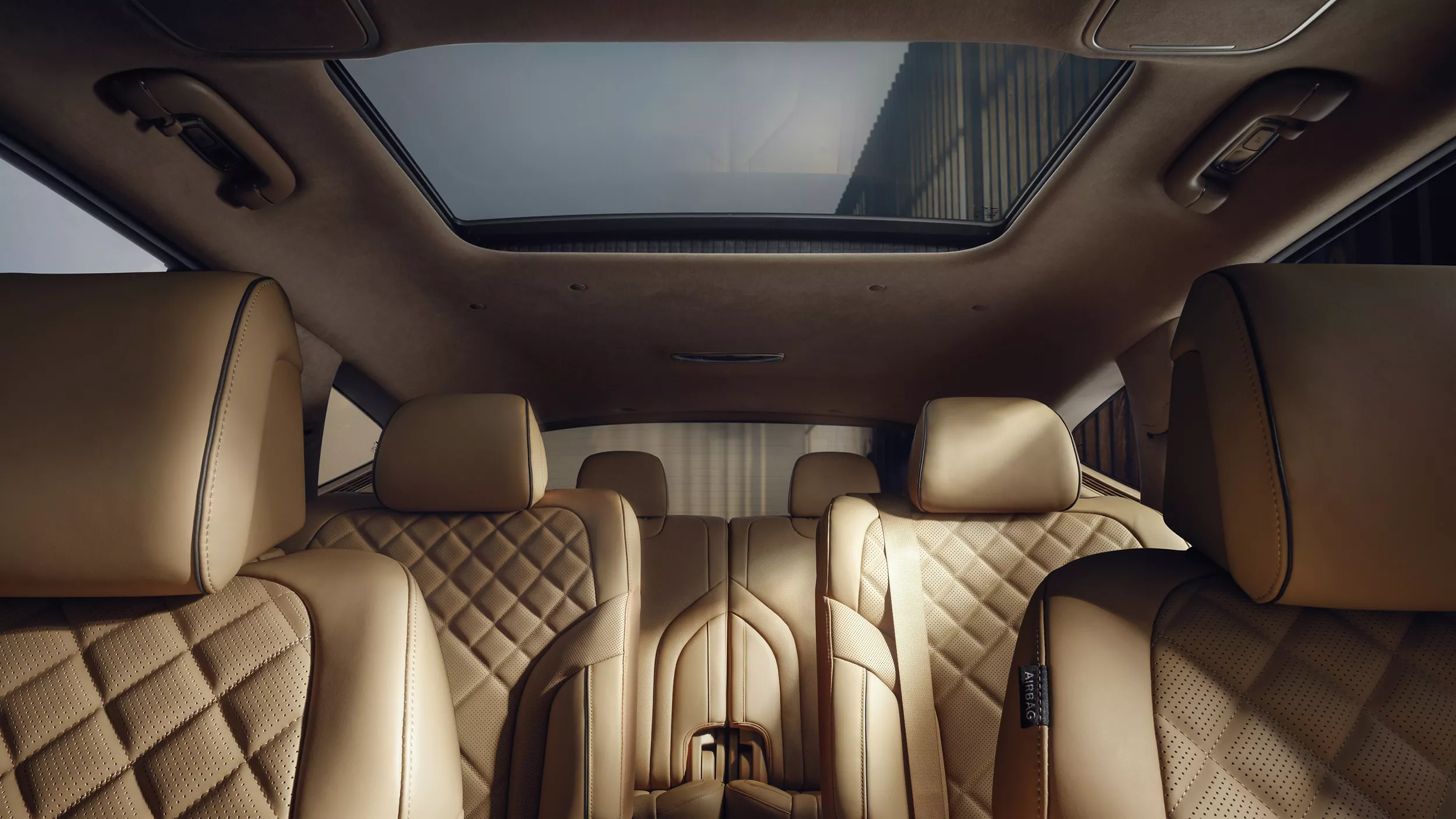 Interior front to back seat pov of Genesis GV80 with tan Nappa leather seats and panoramic sunroof