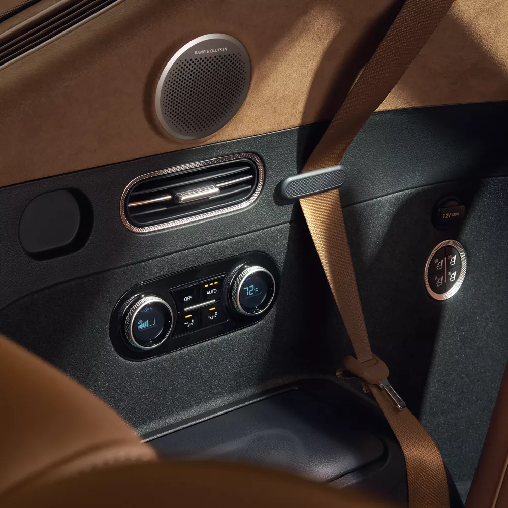 Interior close up of rear seat controls and Bang & Olufsen speaker inside Genesis GV80
