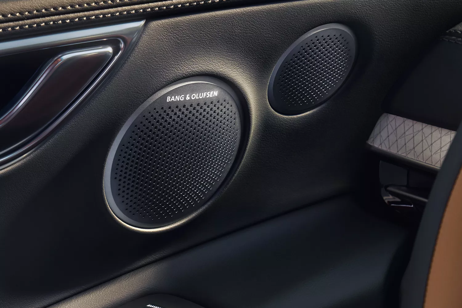 Interior close up of Bang & Olufsen speakers on driver side door panel inside Genesis GV80