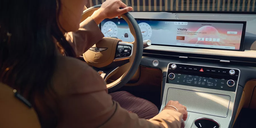 Interior view from backseat of driver in the front seat of Genesis GV80, 27" OLED Display in focus