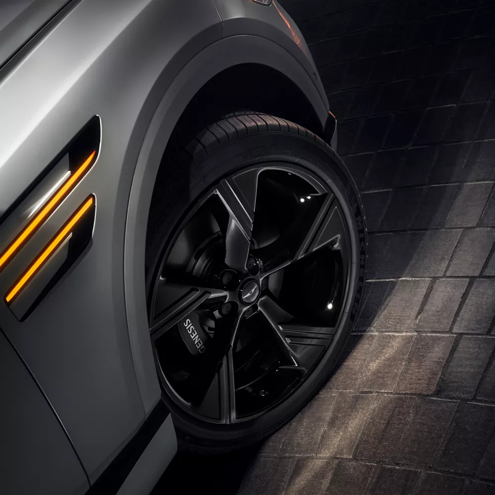 Closeup of the front passenger tire on the Genesis GV80 Prestige Black in Uyuni White