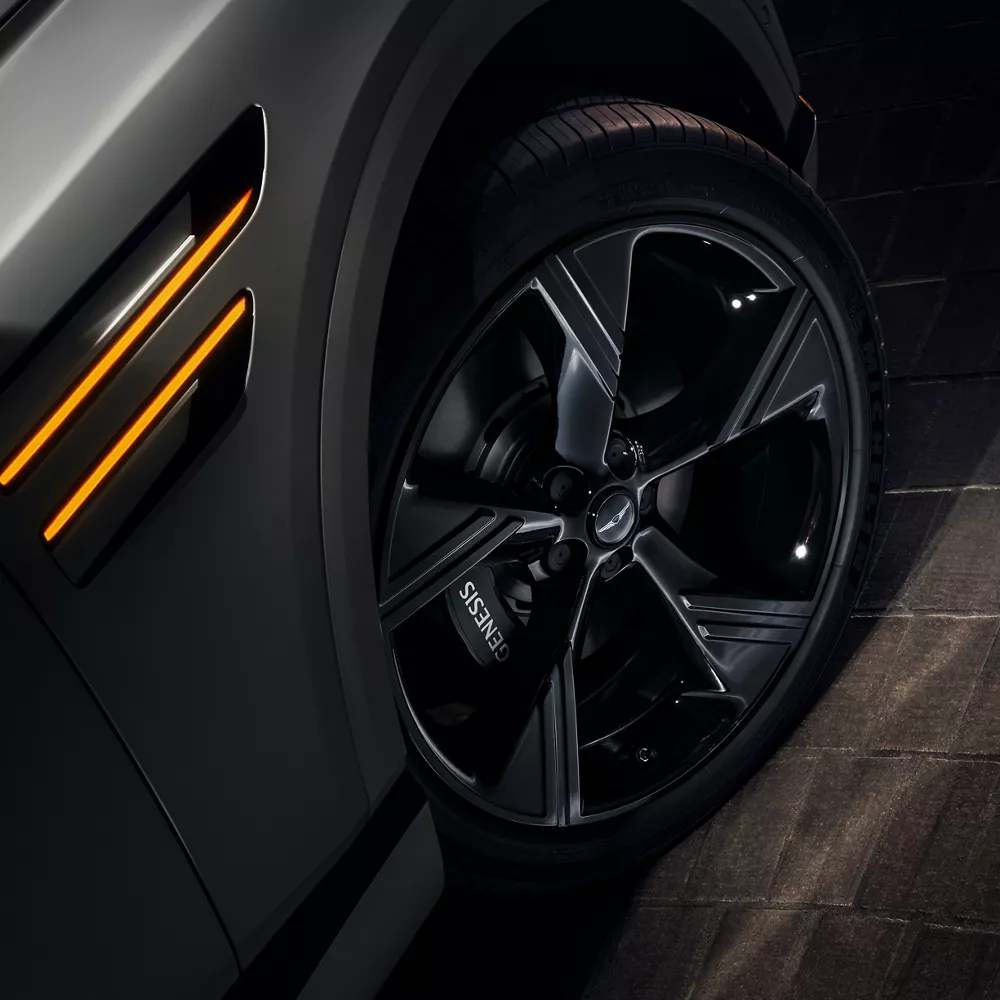 Close-up of black alloy wheel on 2026 Genesis vehicle in Prestige Black trim