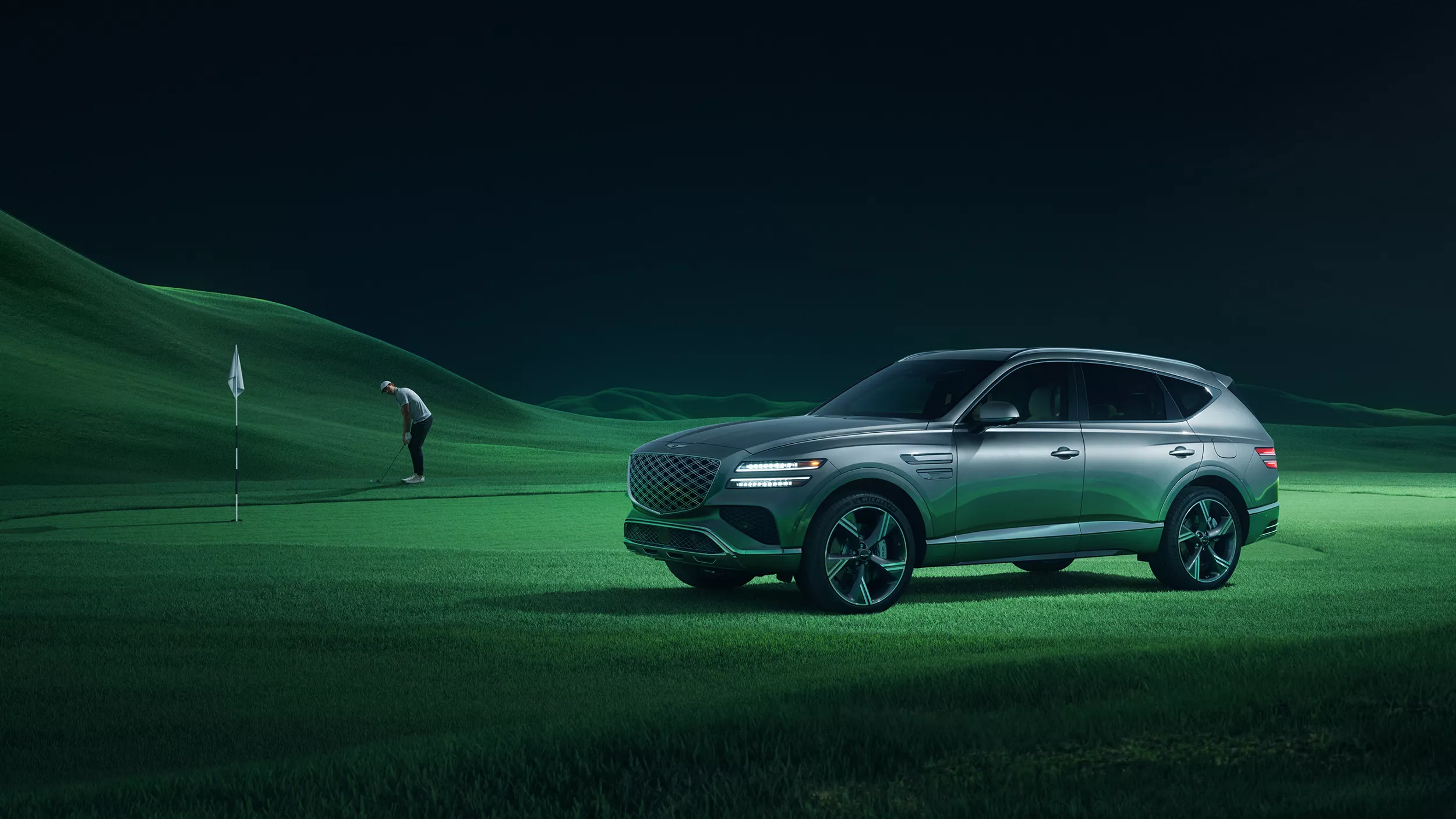 Image of 2026 Genesis GV80 on green rolling hills golf course, with golfer putting in the background