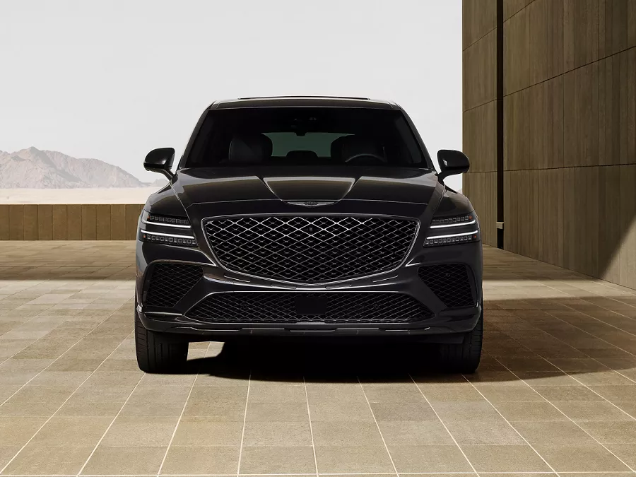 Front facing view of Genesis GV80 Coupe Prestige Black parked in front of modern concrete building
