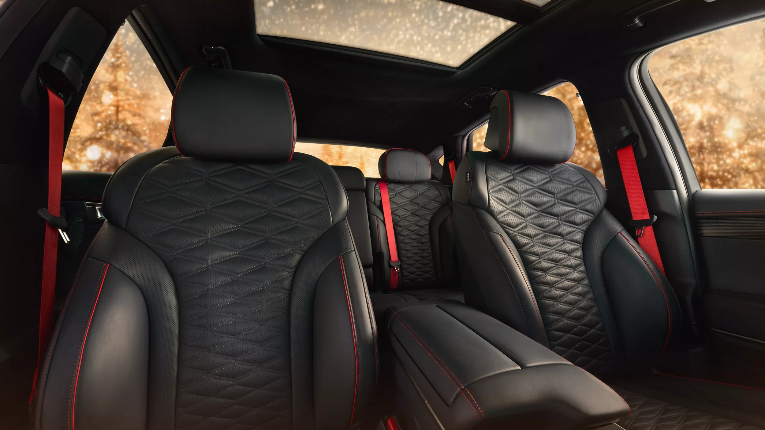 Cabin view from front seat in 2026 Genesis GV80 Coupe with black leather seating, red accents