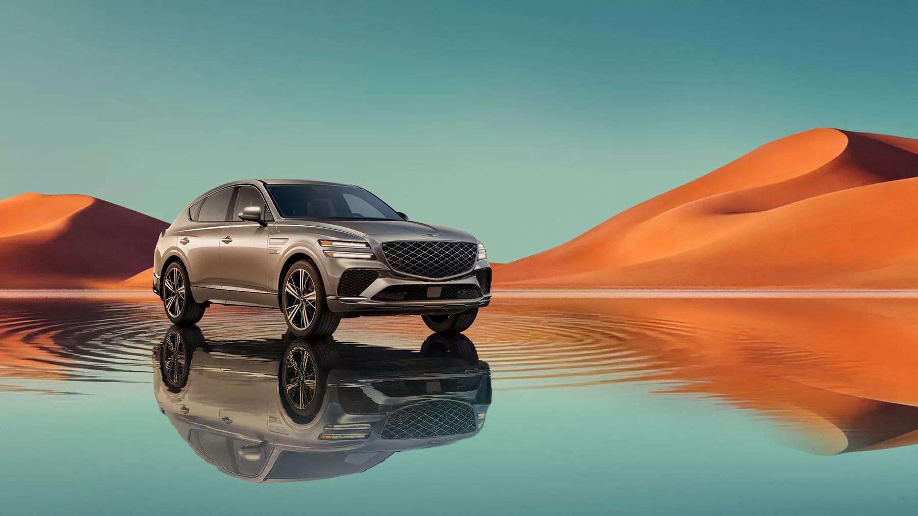 7/8 front passenger view of Savile Silver Genesis GV80 Coupe, blue lake & orange mountain background