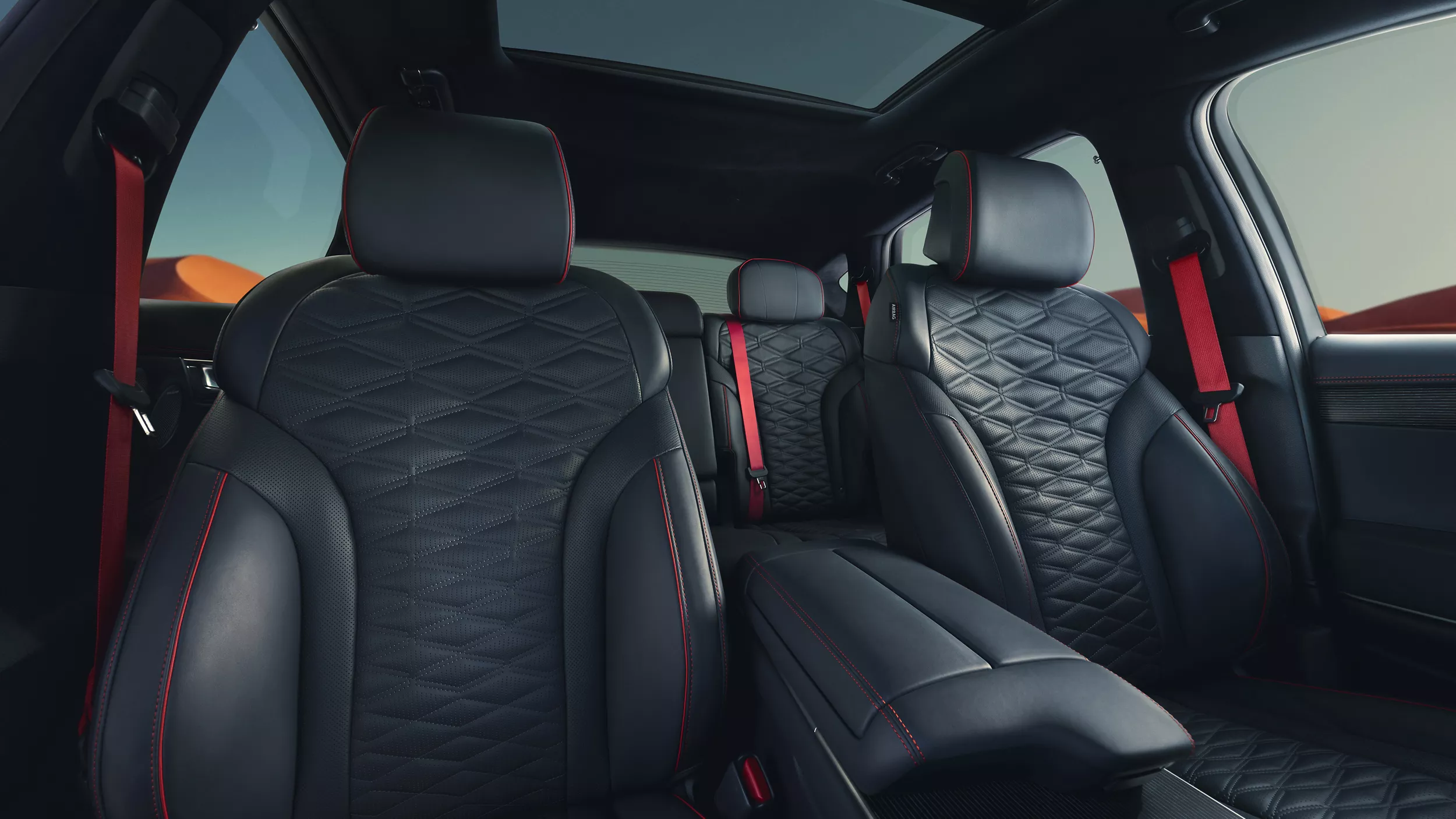 Interior view of blue leather seating inside Genesis GV80 Coupe, mountains and blue sky background
