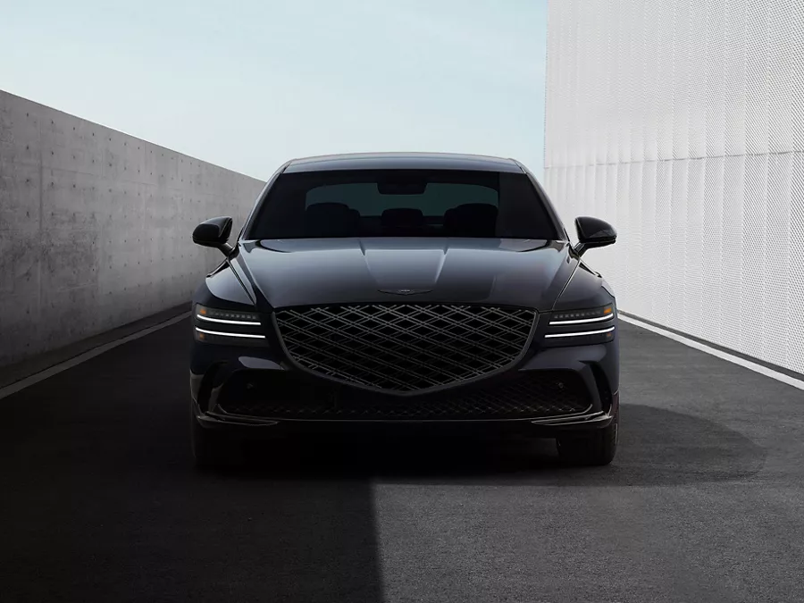 Front view of Genesis G80 Prestige Black parked between modern buildings