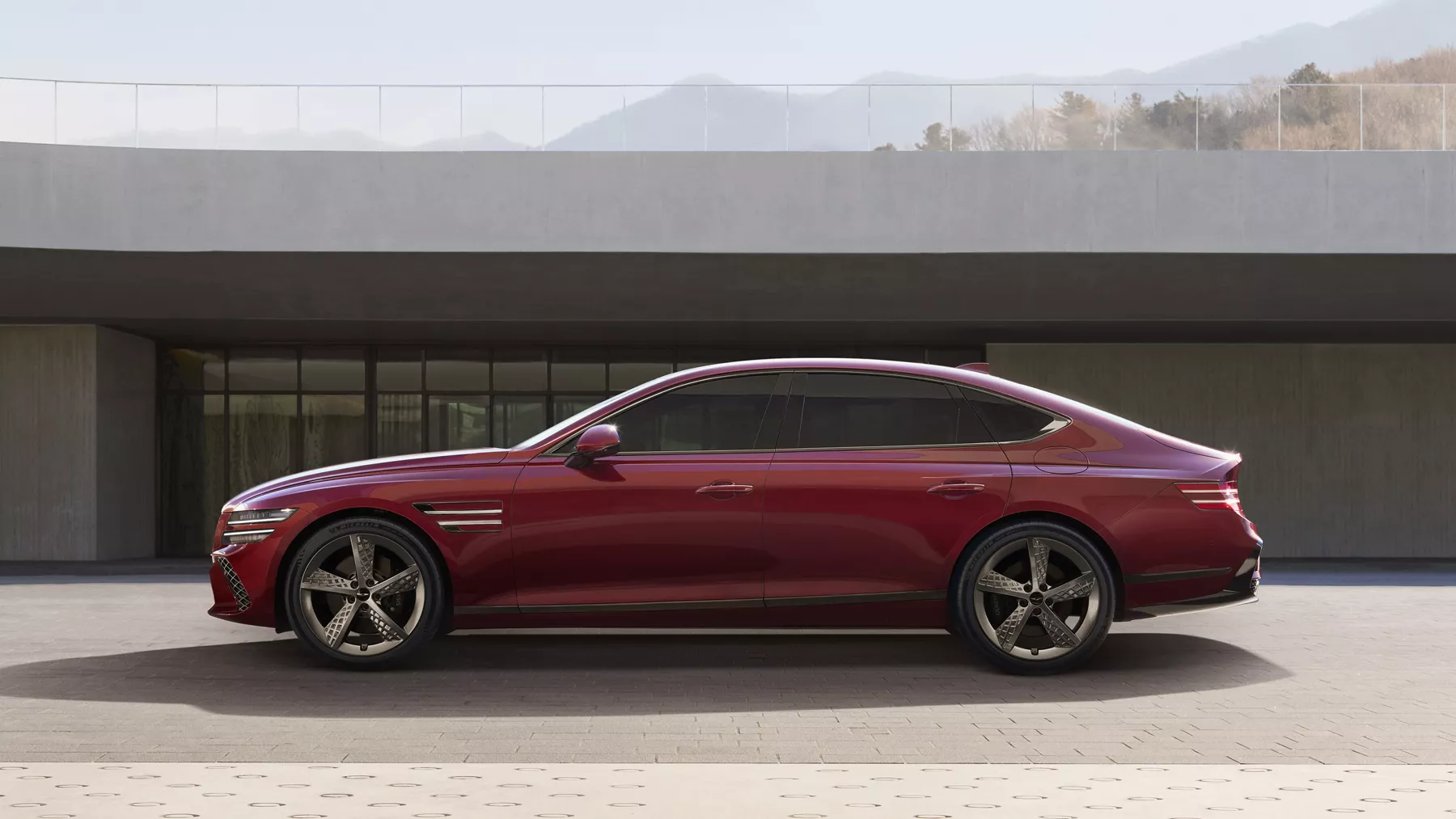 Driver side profile angle of Genesis G80 in Cavendish Red parked with in front of modern house