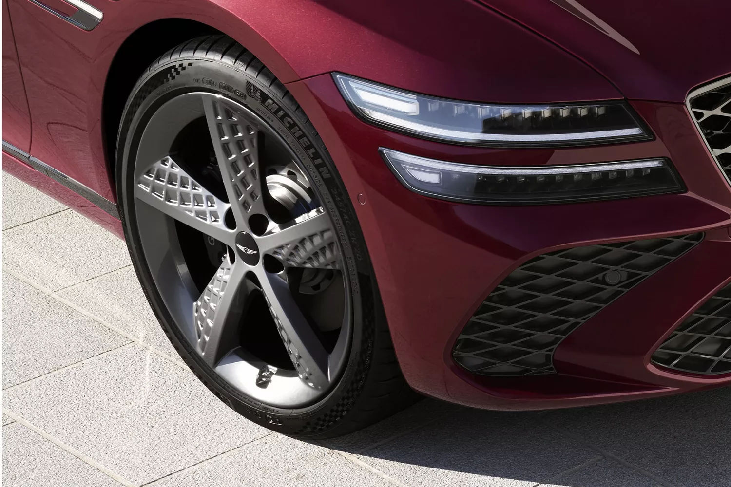 Wheel and tire closeup on Genesis G80 in Cavendish Red