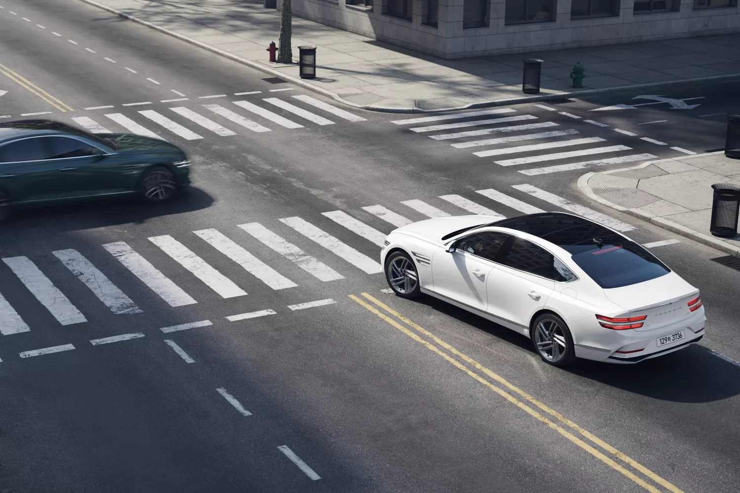 White Genesis G80 at intersection demonstrating collision avoidance