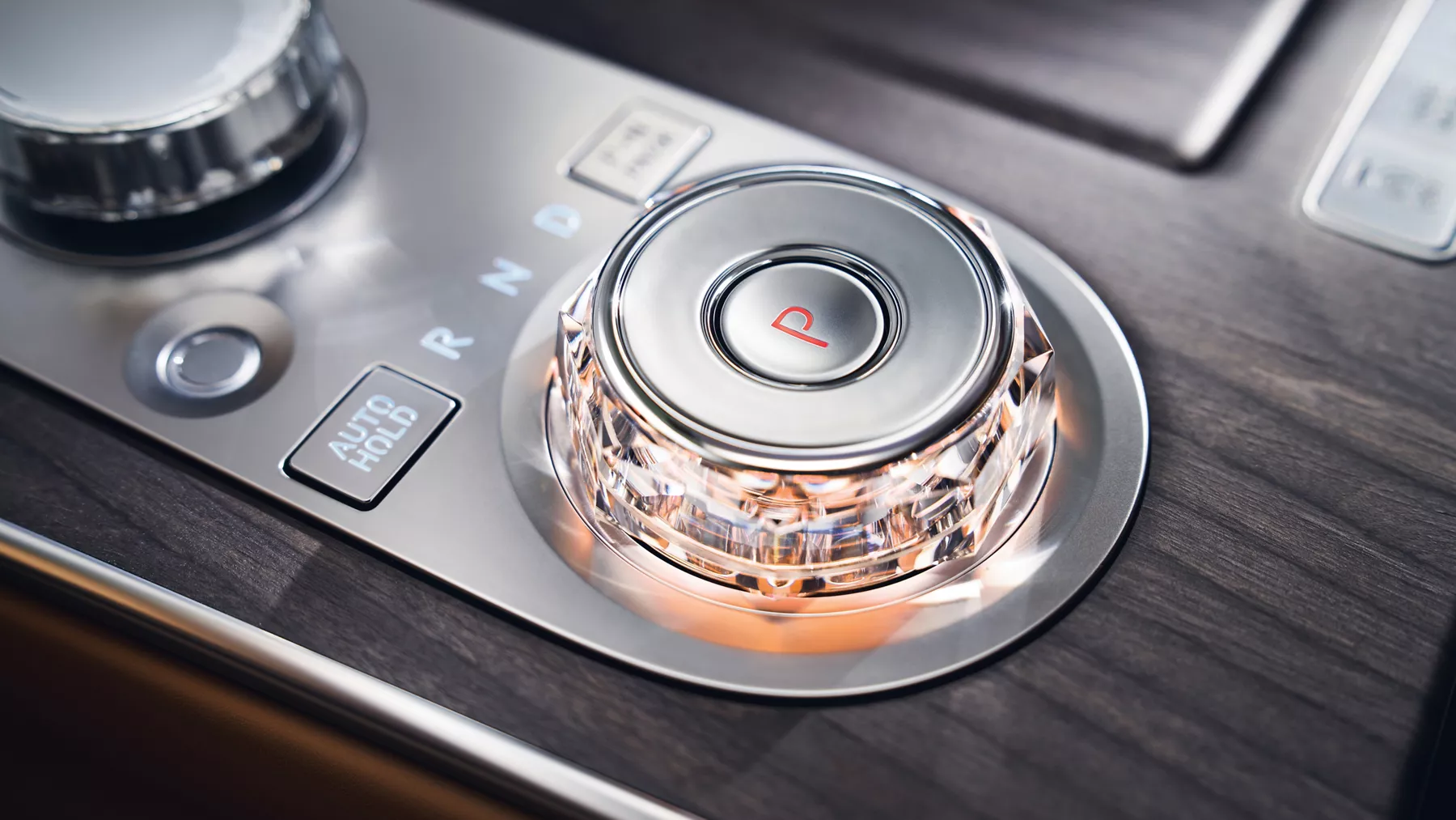 Interior close up shift by wire gear selector wheel with red ambient light inside the Genesis G80