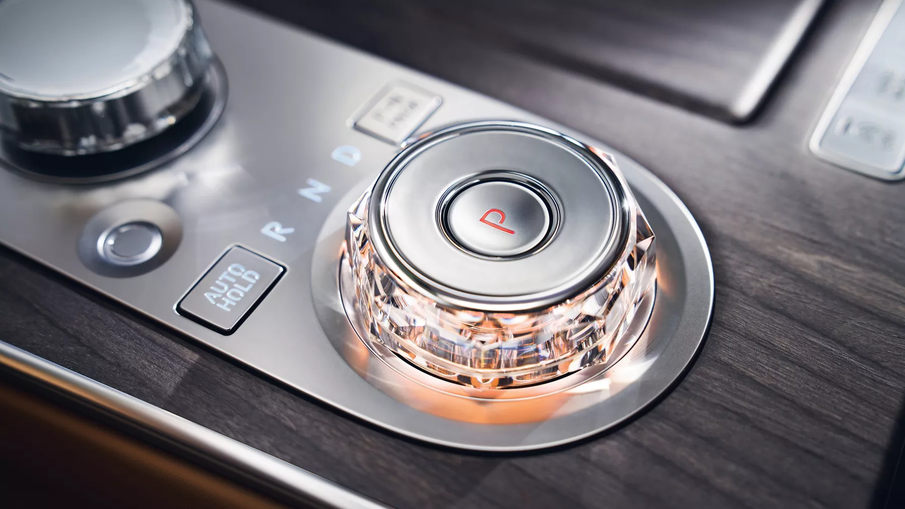 Interior close-up of Genesis G80 gear selector with crystal knob in black wood accent center console