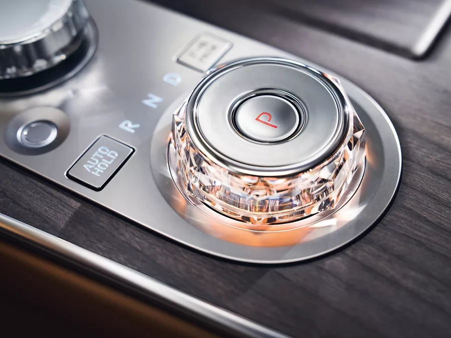 Interior close-up of Genesis G80 gear selector with crystal knob in black wood accent center console