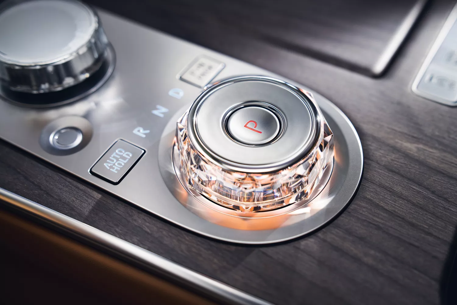 Interior close-up of Genesis G80 gear selector with crystal knob in black wood accent center console