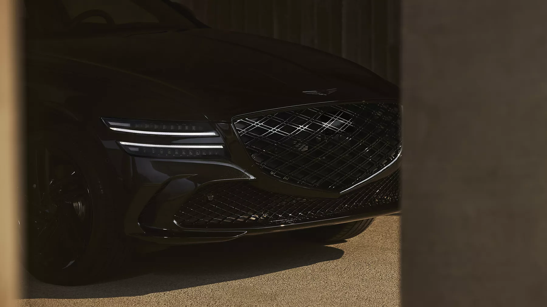 Close up of grille and illuminated head lights on 2026 Genesis G80 Prestige Black