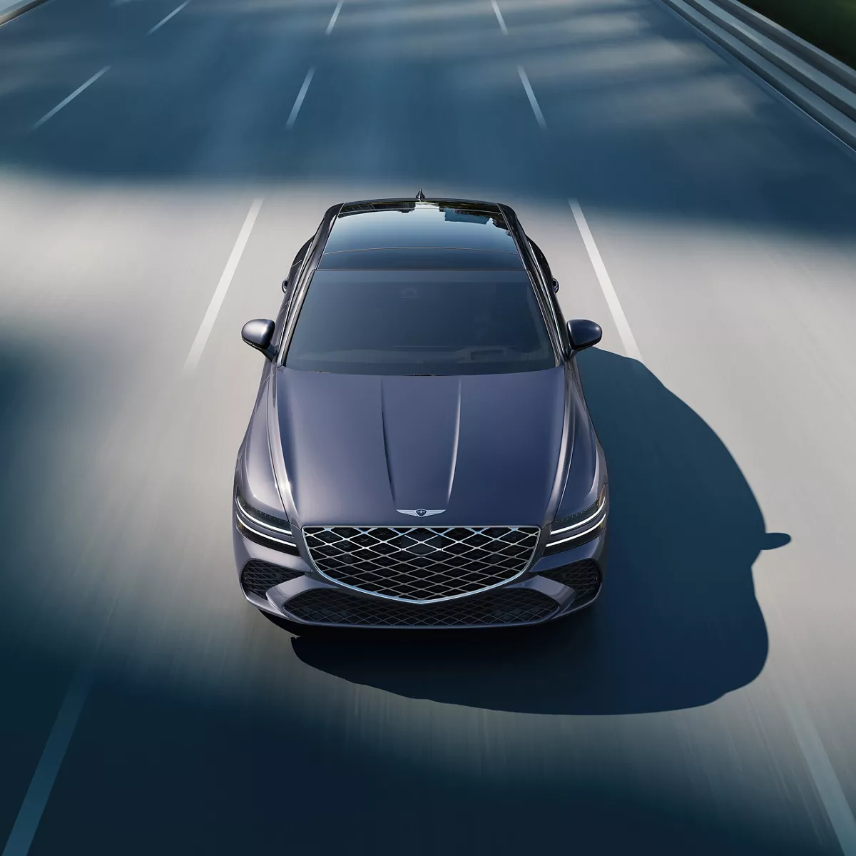 Front high angle view of Genesis G80 in Ceres Blue in motion driving on city street