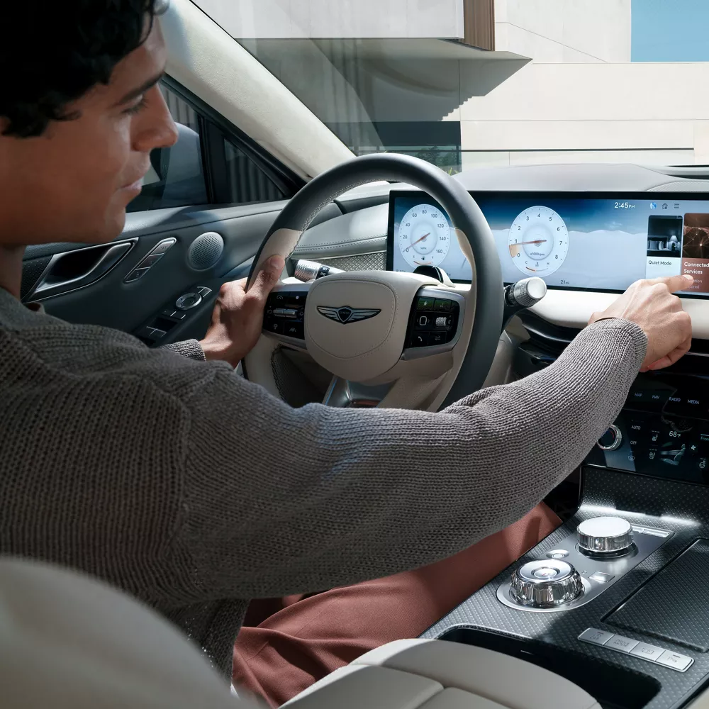 Interior over the shoulder view of driver inside Genesis G80 using 27 inch OLED display