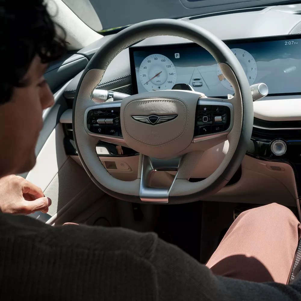 Interior over the should view of driver in driver seat of Genesis G80