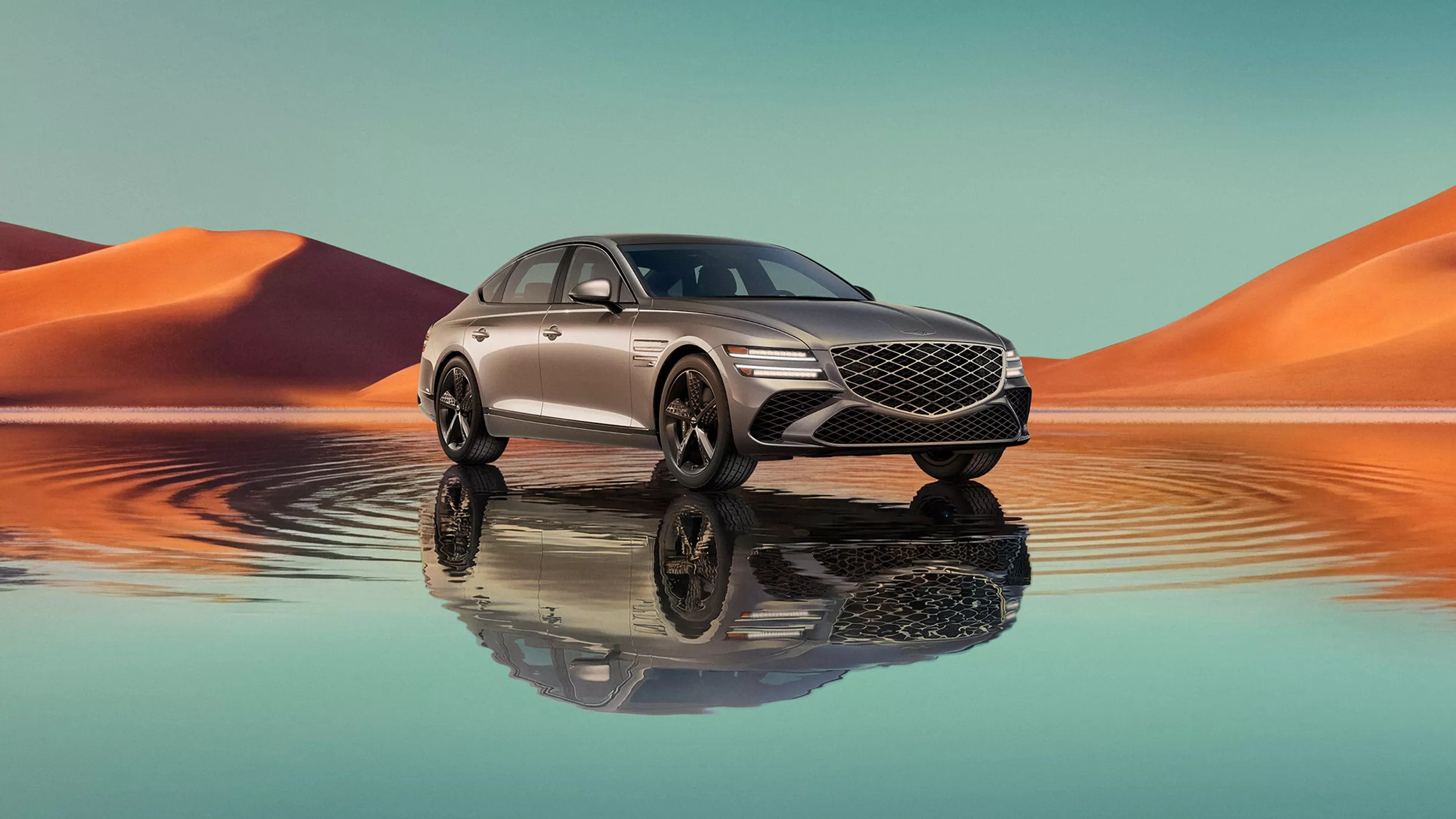 7/8 front passenger view of Savile Silver Genesis G80 on blue lake w/ orange mountain in background