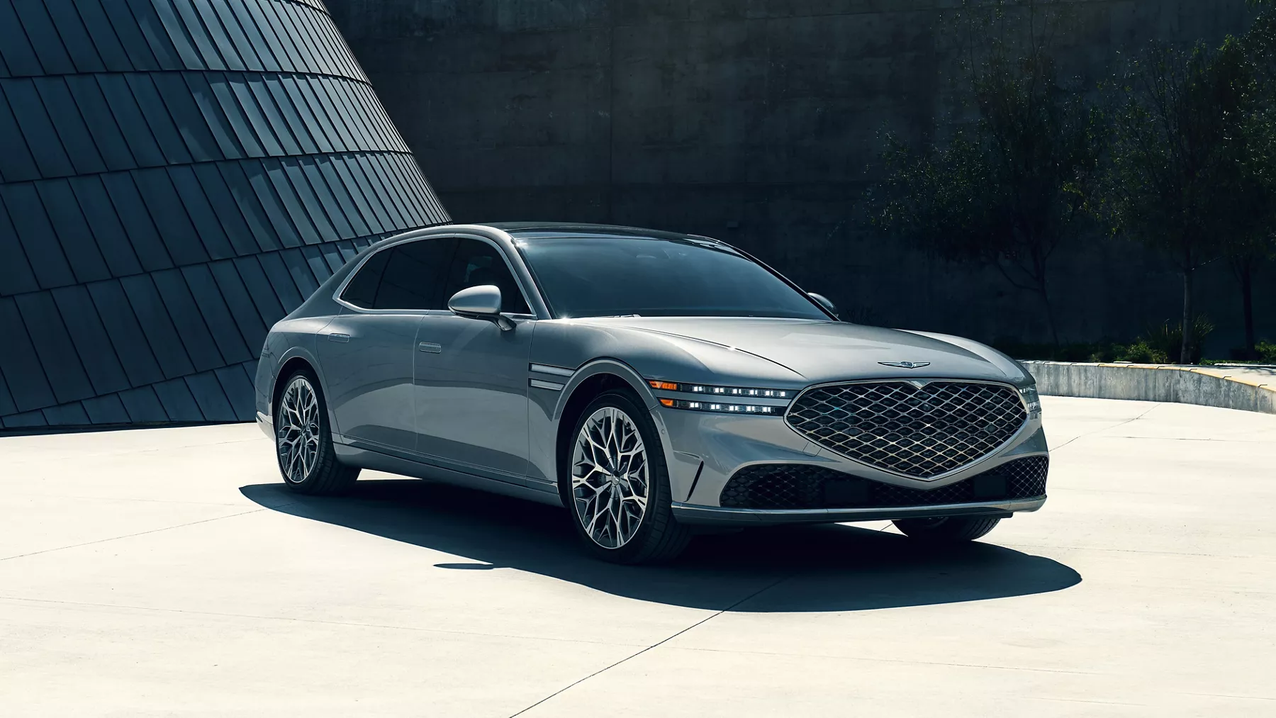 3/4 front passenger's side angle of 2026 Genesis G90 in Savile Silver on rooftop of modern building