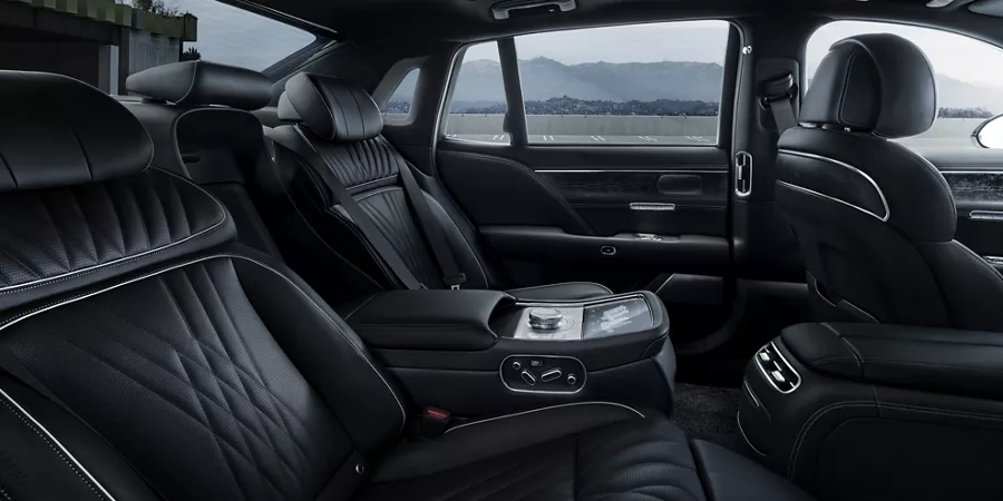 Rear passenger view of 2026 Genesis G90 interior in Black Monotone, with mountains in background