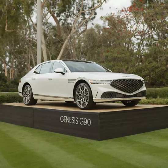 Front passenger side view of Genesis G90 in white on display on the green at Genesis Invitational