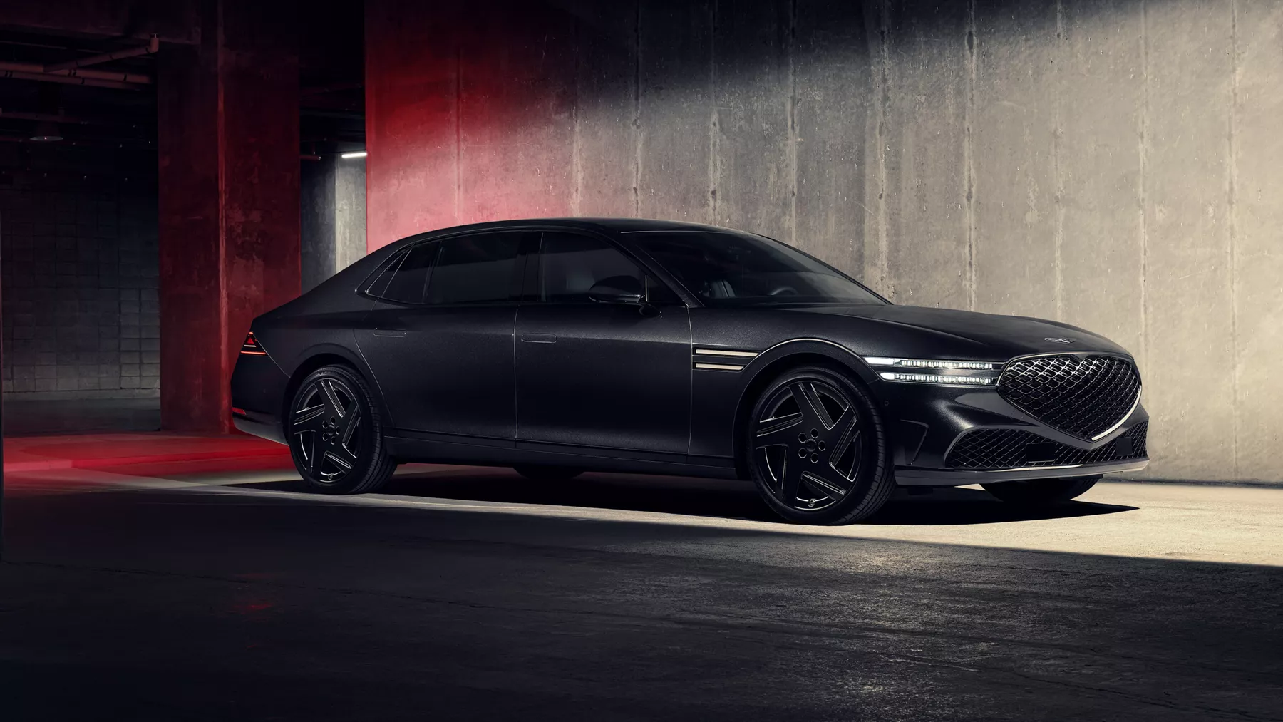 Passenger side profile view of 2026 Genesis G90 in Prestige Black parked in dimly lit parking garage