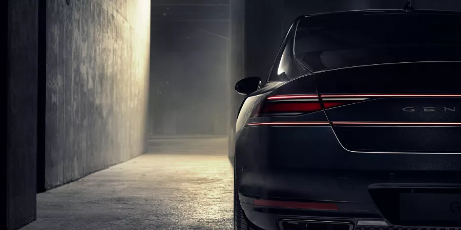 Rear closeup of 2026 Genesis G90 in Prestige Black parked in a dimly lit parking garage
