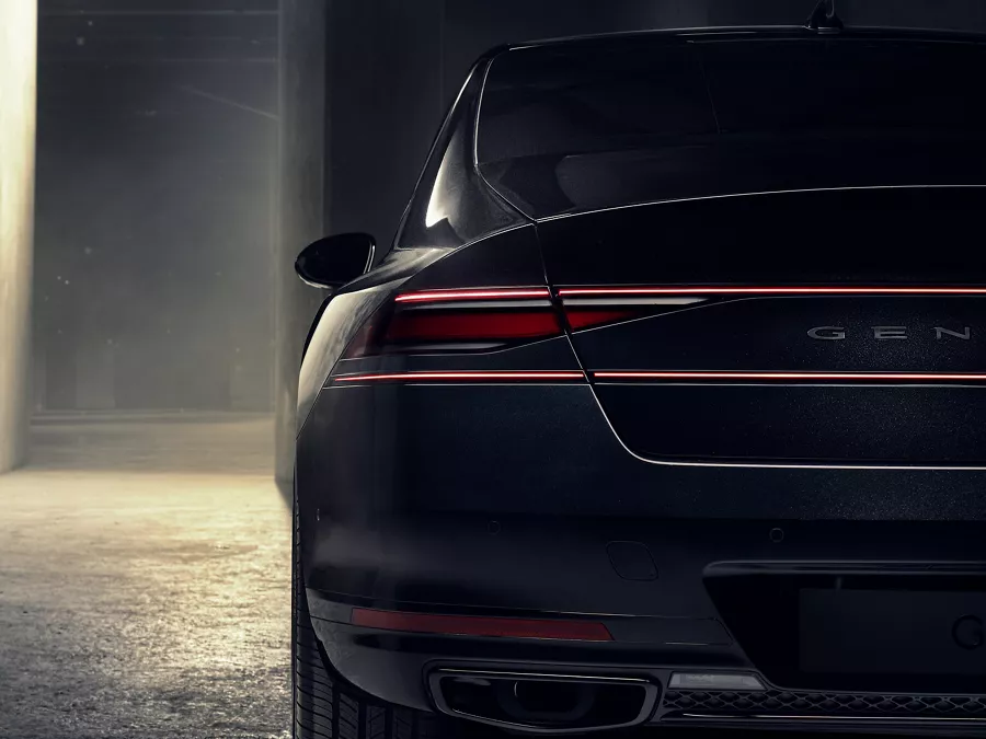Rear closeup of 2026 Genesis G90 in Prestige Black parked in a dimly lit parking garage