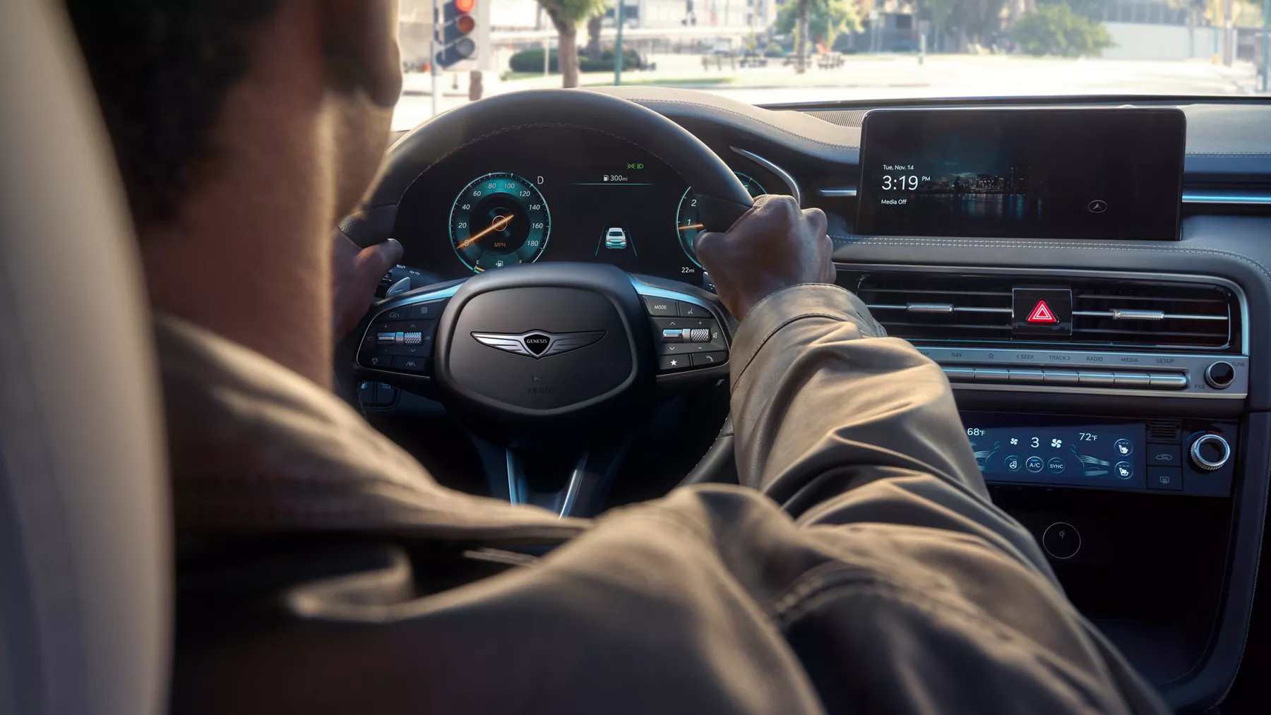 Interior over-the-shoulder pov of a driver holding the steering wheel inside the Genesis G70