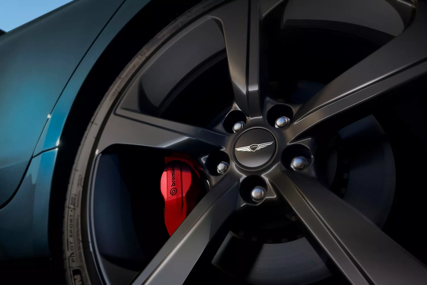 Close up of wheel and brake caliper details on 2027 Genesis G70 in Tasman Blue