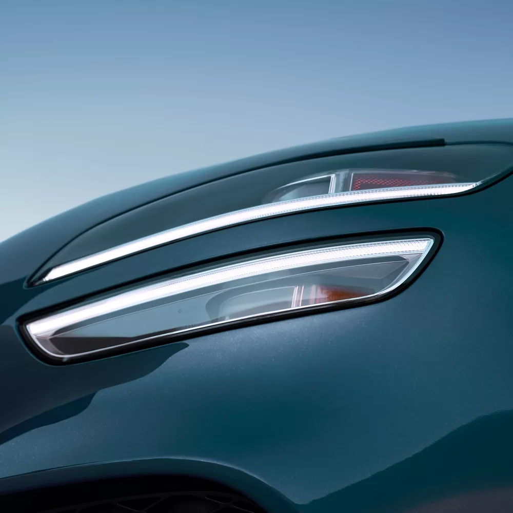 Closeup of headlight on 2027 Genesis G70 in Tasman Blue