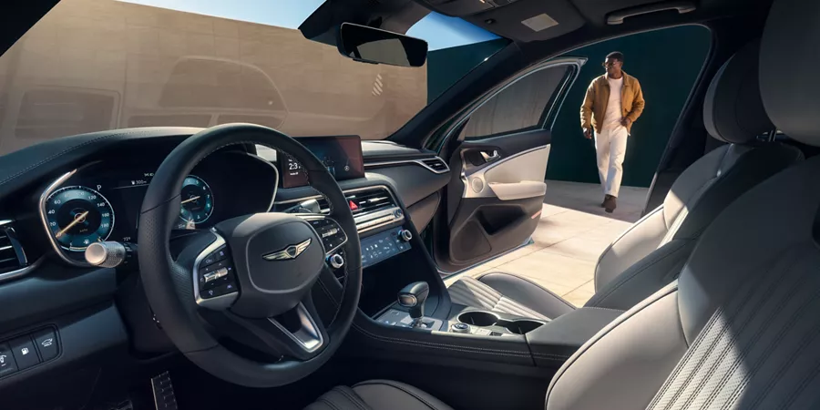 Interior driver side pov of 2027 Genesis G70, passenger door open, man walking toward vehicle