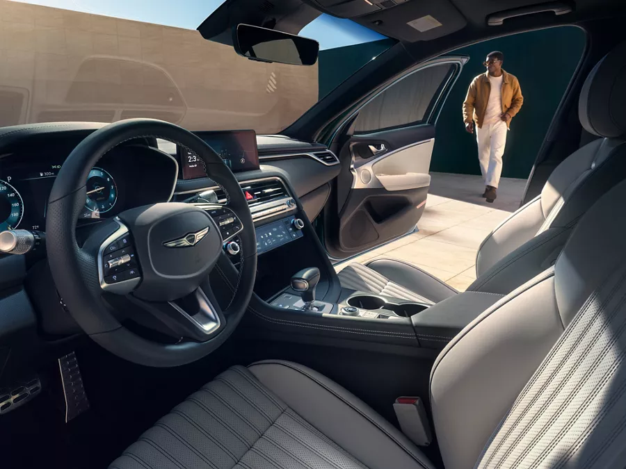 Interior driver side pov of 2027 Genesis G70, passenger door open, man walking toward vehicle