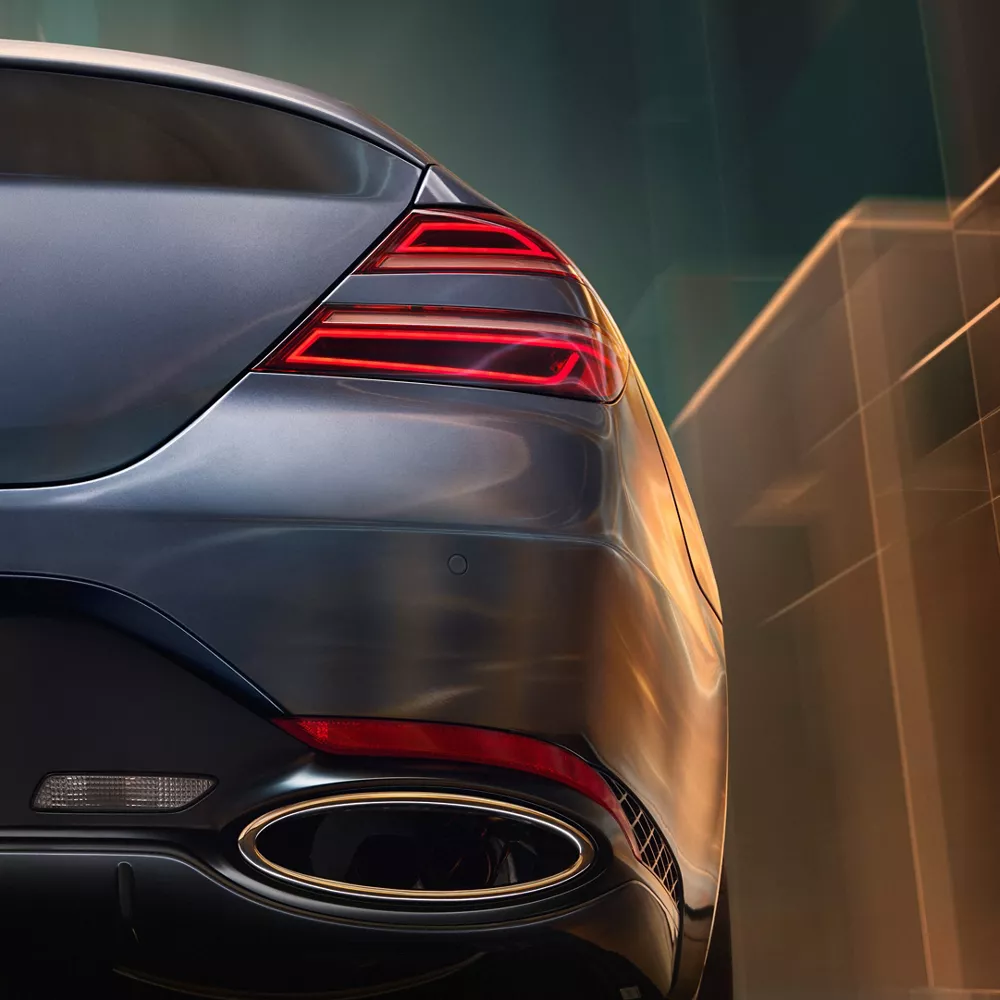 Rear passenger side close up of exhaust and tail light on 2027 Genesis G70 Prestige Graphite