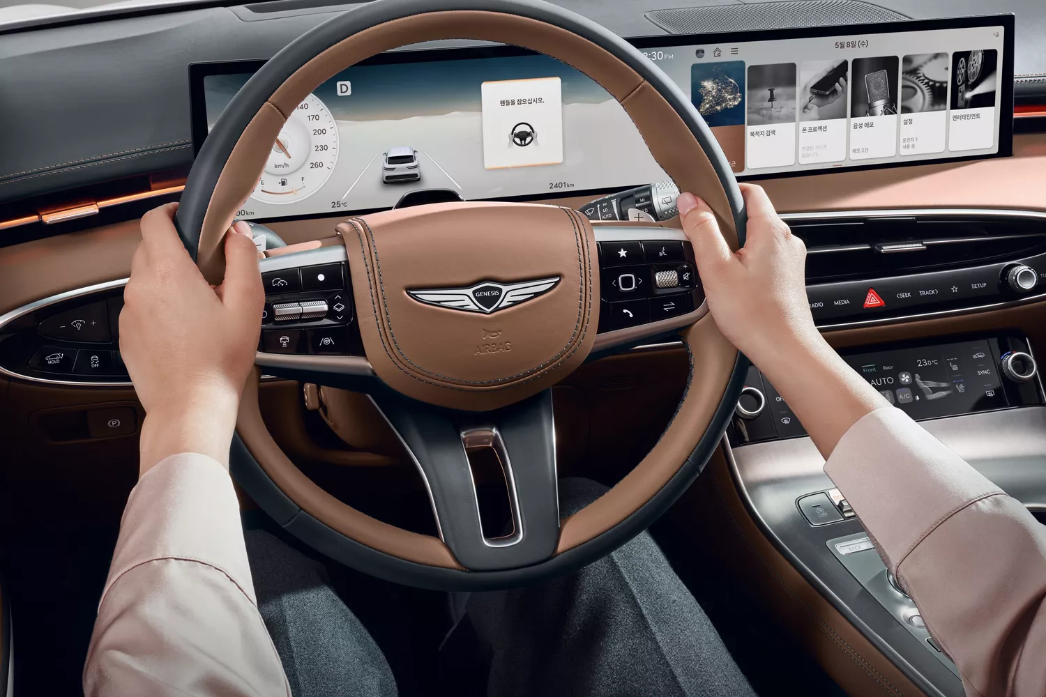 Close up view of a driver holding a Genesis GV70 steering wheel