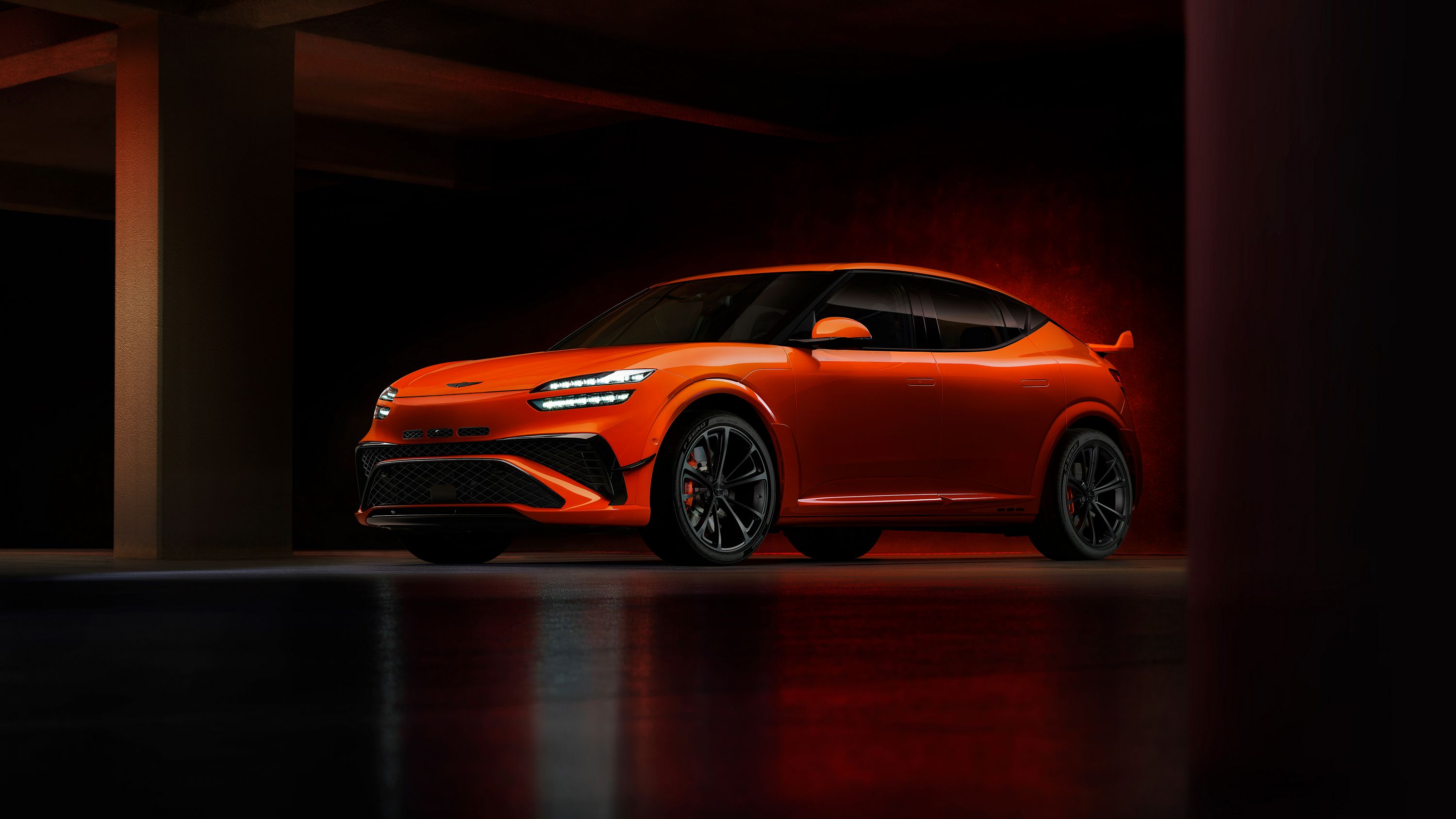 Genesis GV60 Magma в оранжевом цвете, вид спереди три четверти