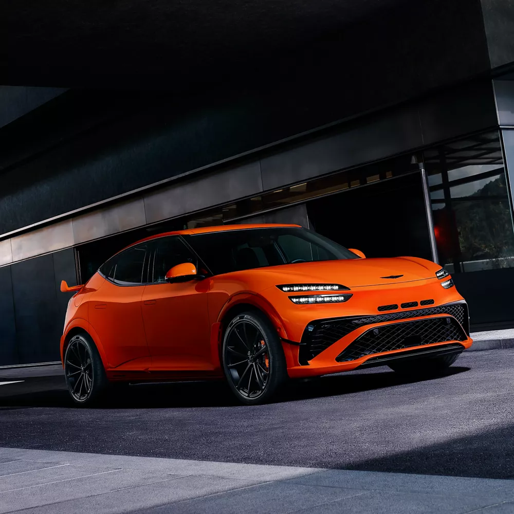 3/4 front driver side view of 2027 Genesis GV60 Magma in orange