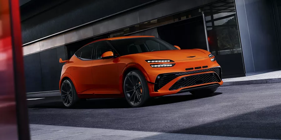 3/4 passenger side view of 2027 Genesis GV60 Magma in orange
