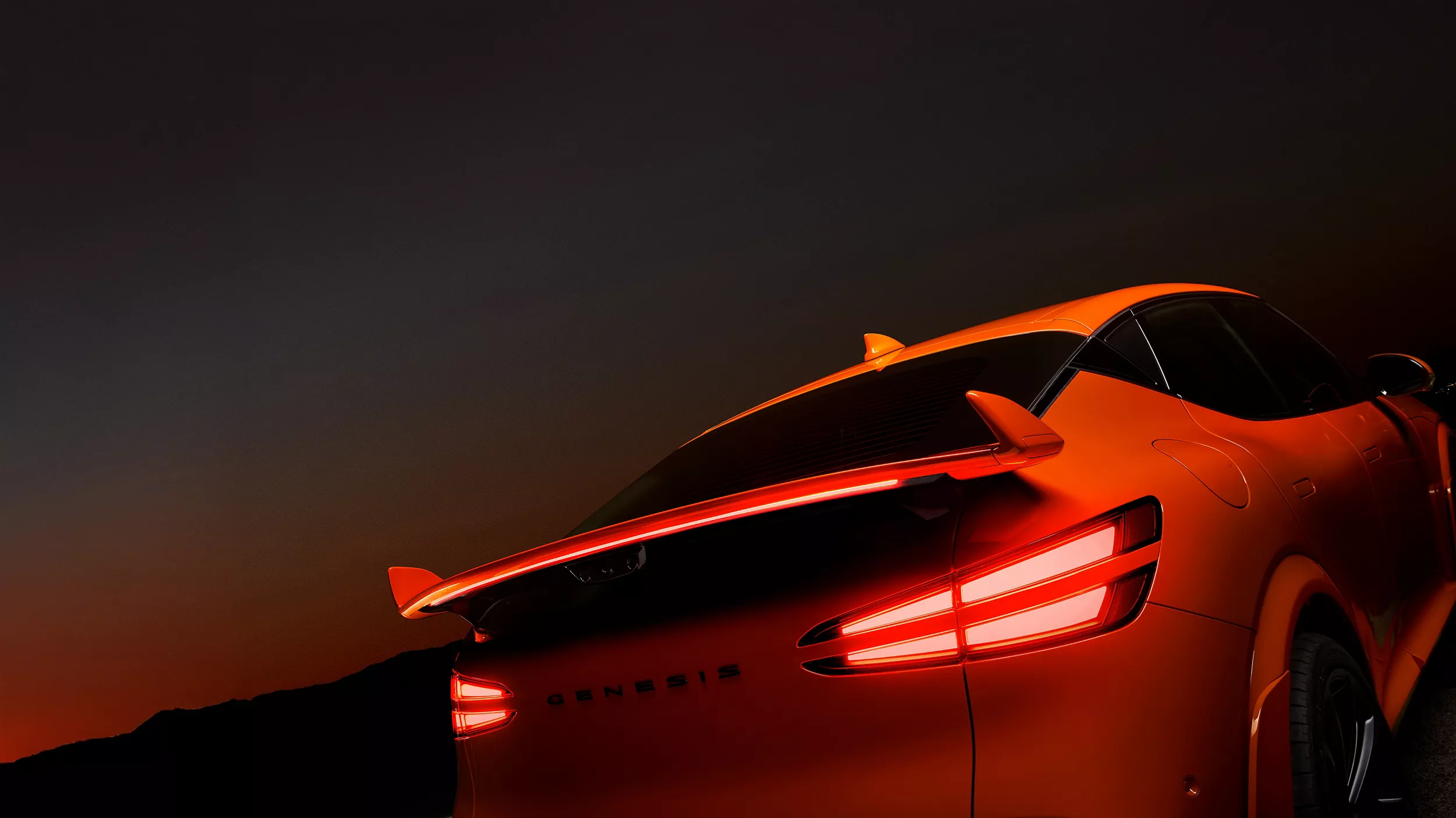 Rear spoiler and brake lights close up on 2027 Genesis GV60 Magma in orange